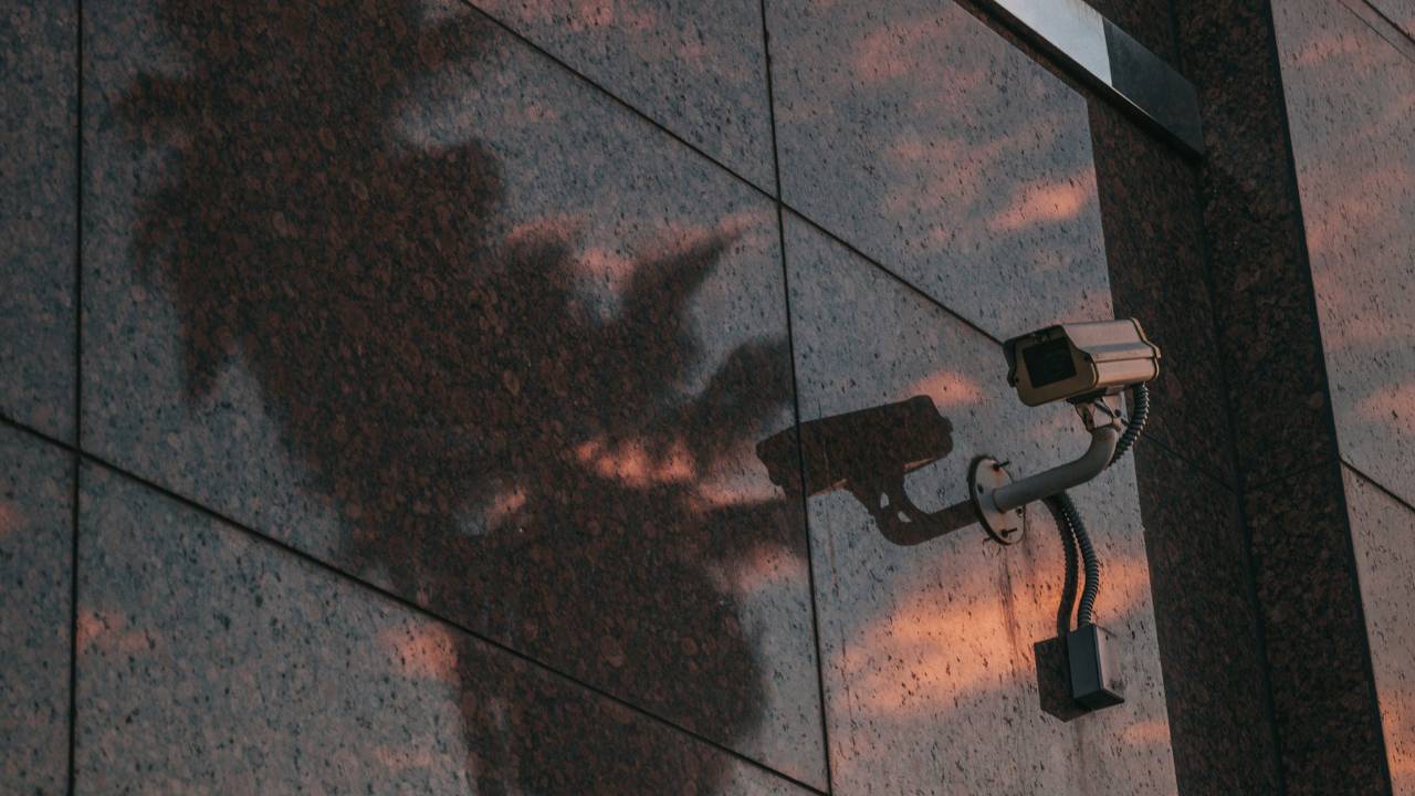 A CCTV camera mounted on a reflective wall