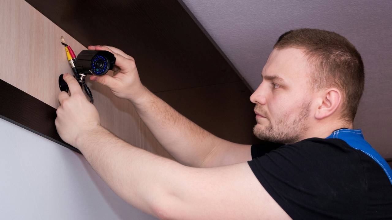 A man installing a small CCTV camera