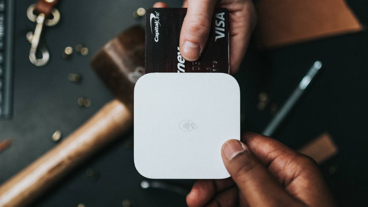 A customer paying a salesperson with a VISA card